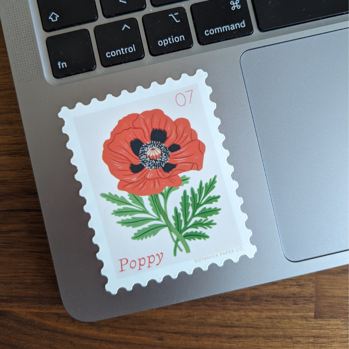 Autocollant en forme de timbre avec une illustration de coquelicot.