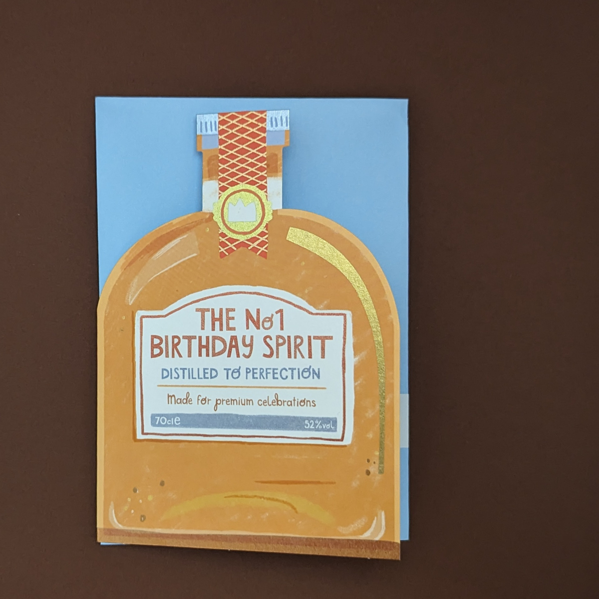 Carte d'anniversaire en forme de bouteille avec de la dorure et un jeu de mot anglais écrit sur l'étiquette de la bouteille pour souhaiter un bon anniversaire à un de vos proches.