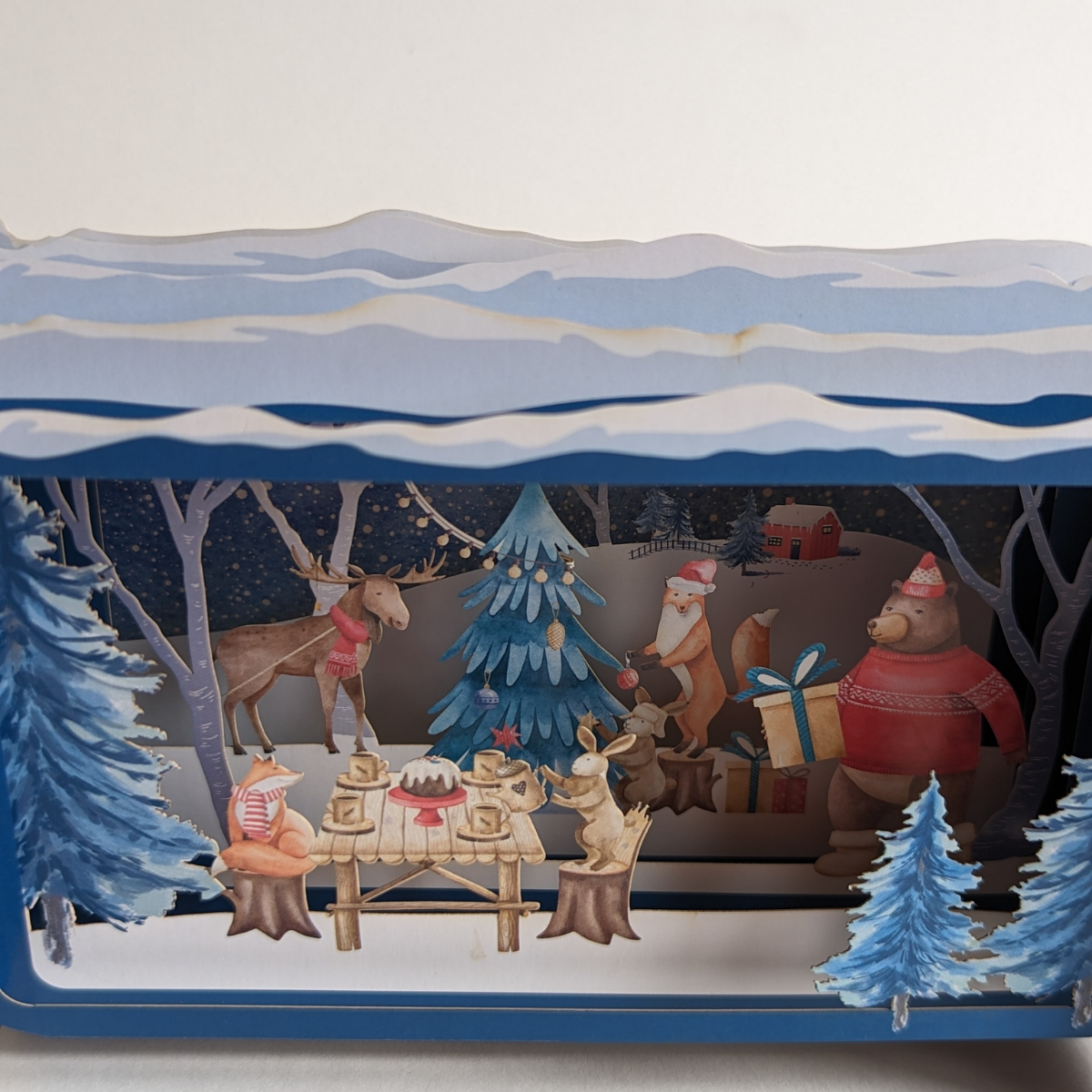 Cette carte exceptionnelle est un petit univers de magie et d'émerveillement. Une carte en forme de bouteille avec à l'intérieur, une scène magique mettant en vedette des adorables animaux de la forêt en train de célébrer Noël.