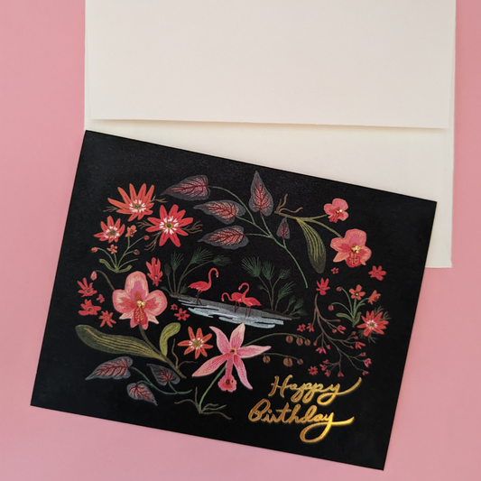 Une végétation luxuriante : orchidées et autres plantes dans les tons de rose entourent un plan d'eau dans lequel se rassemblent trois beaux flamants roses.