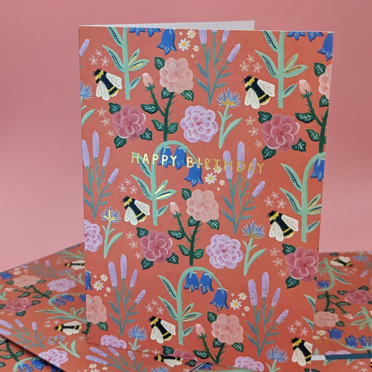 Sur un fond fleuri telle une prairie anglaise, des bourdons volent d'une fleur à l'autre. Une carte brillante et élégante pour souhaiter un bon anniversaire à vos proches.
