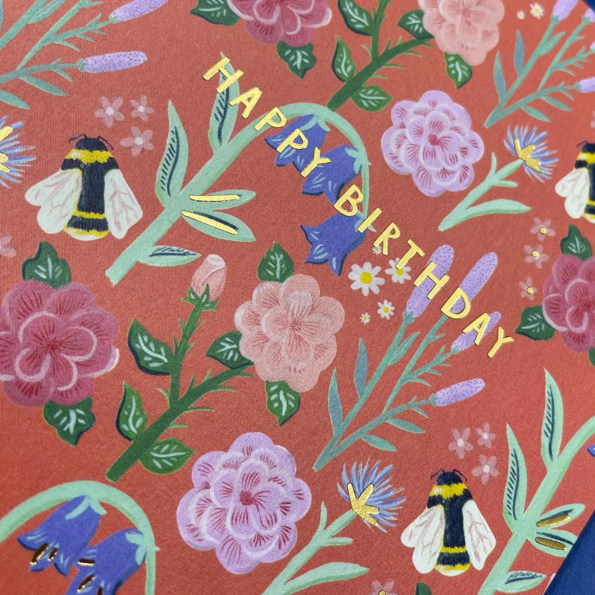 Sur un fond fleuri telle une prairie anglaise, des bourdons volent d'une fleur à l'autre. Une carte brillante et élégante pour souhaiter un bon anniversaire à vos proches.