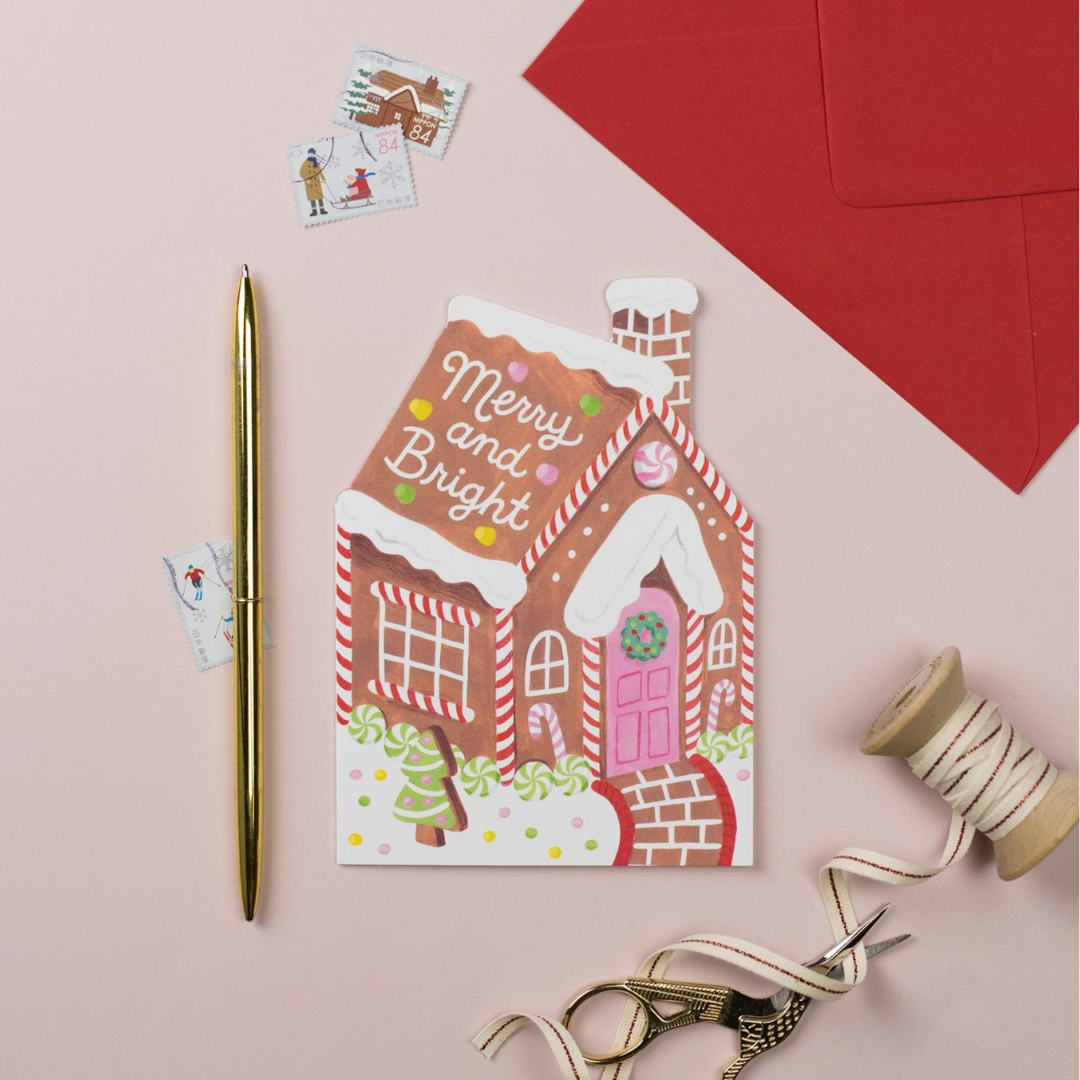 Cette charmante carte en forme de maison en pain d'épices évoque les douceurs de Noël.