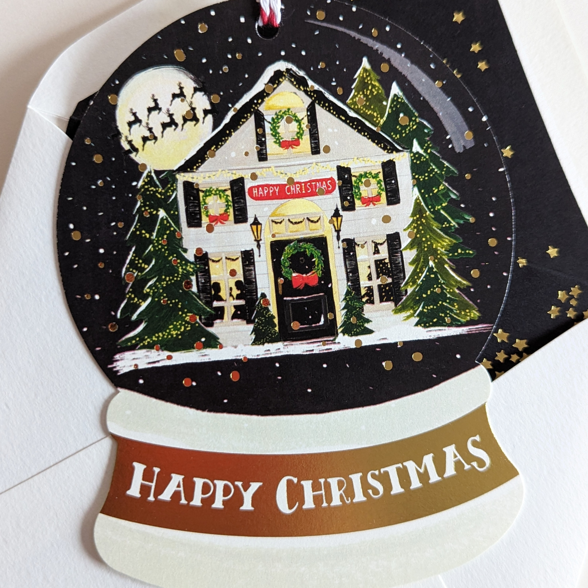 Carte Happy Christmas découpée en forme de boule à neige. Dessinée par The First Snow.