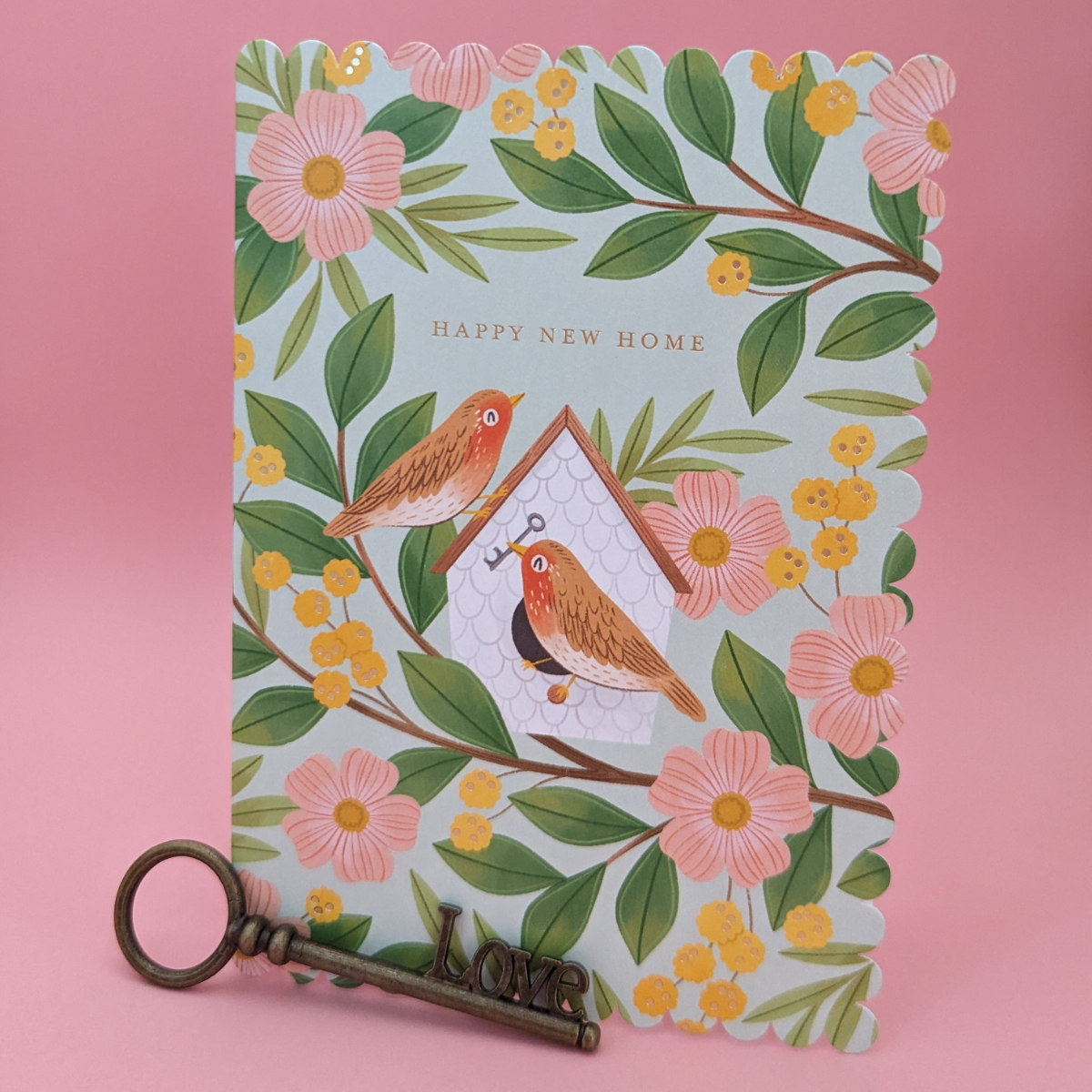 Cette carte découpée à l’emporte-pièce est ornée de deux adorables rouges-gorges qui emménagent dans leur nouveau nichoir entouré de fleurs colorées. C'est le début d'une nouvelle vie et de merveilleux souvenirs à venir.
