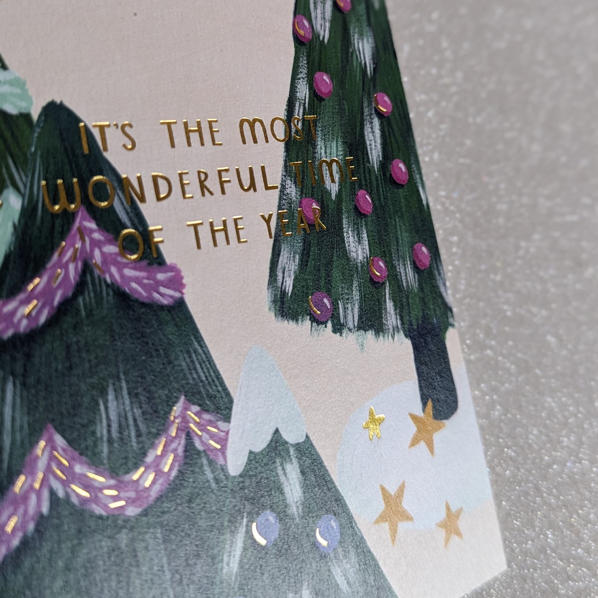 Carte de Noël avec Trois sapins décorés et des touches de dorure.