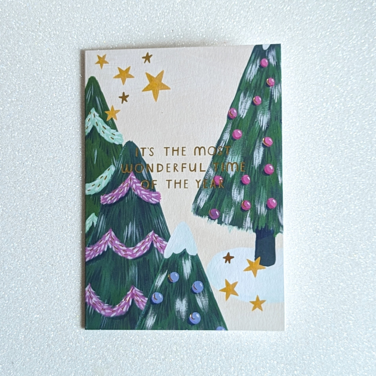 Carte de Noël avec Trois sapins décorés et des touches de dorure.