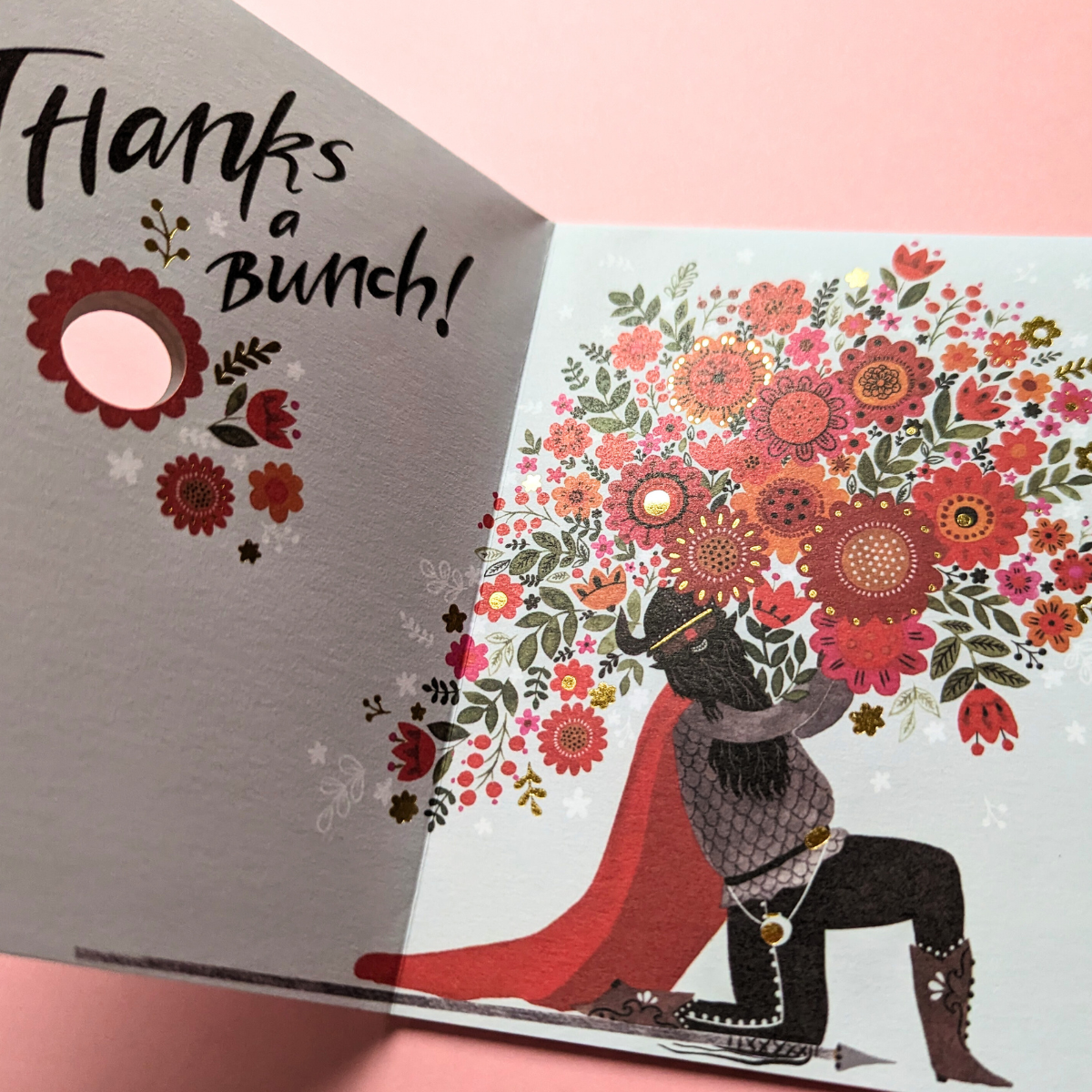 Lorsque vous ouvrez la carte : un viking tient un énorme bouquet de fleurs aux couleurs vives, créant ainsi un contraste saisissant entre la force brute des vikings et la délicatesse des fleurs.