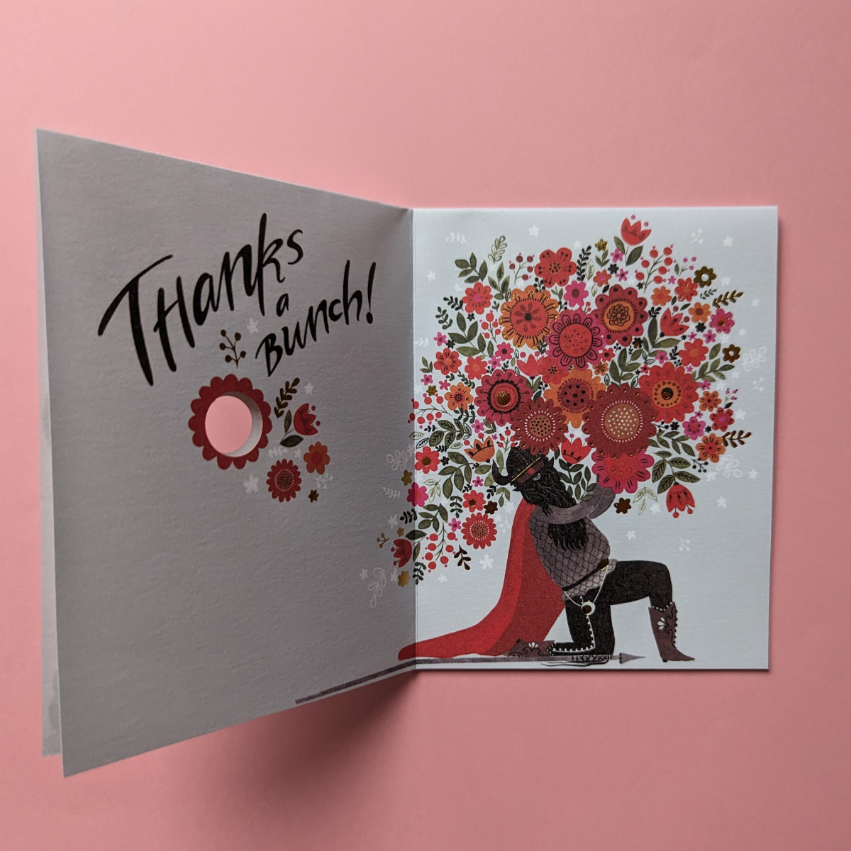 Lorsque vous ouvrez la carte : un viking tient un énorme bouquet de fleurs aux couleurs vives, créant ainsi un contraste saisissant entre la force brute des vikings et la délicatesse des fleurs.