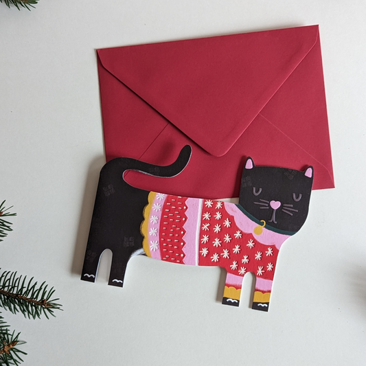 Carte en forme de chat. Il porte un pull de Noël.