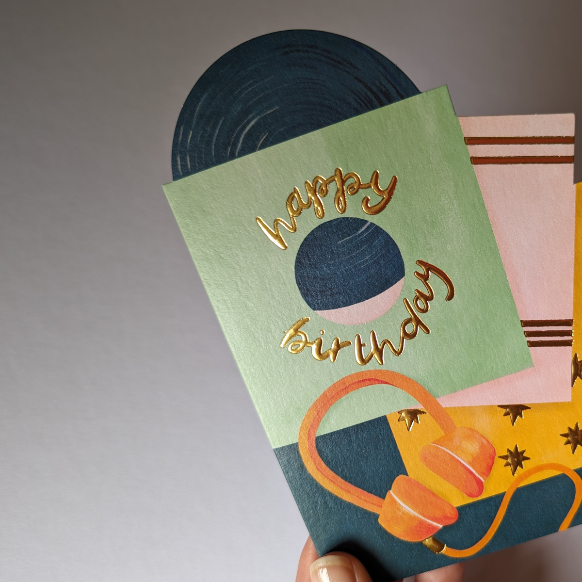 Une carte d'anniversaire parfaite pour ceux qui aiment la musique. Le design comprend une collection de disques vinyles avec une forme découpée et d'élégants détails en feuille d'or.