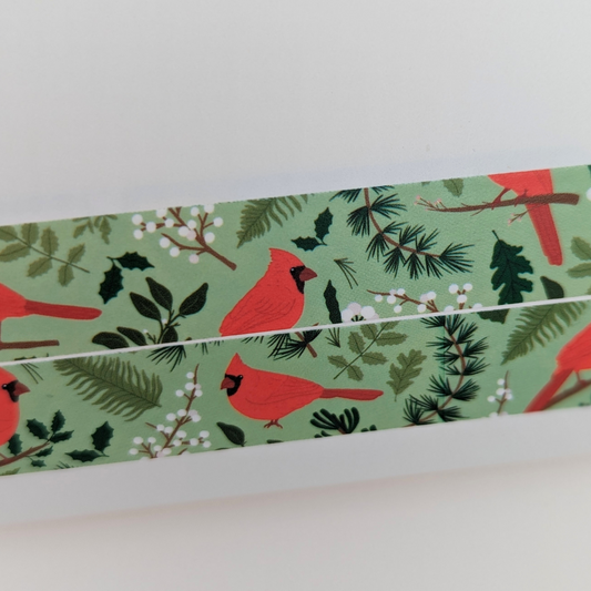 Pour ajouter une touche de féérie à vos projets créatifs, ce rouleau de masking tape décoré d'un cardinal rouge est parfait pour embellir vos cartes de vœux, cadeaux et décorations de Noël.