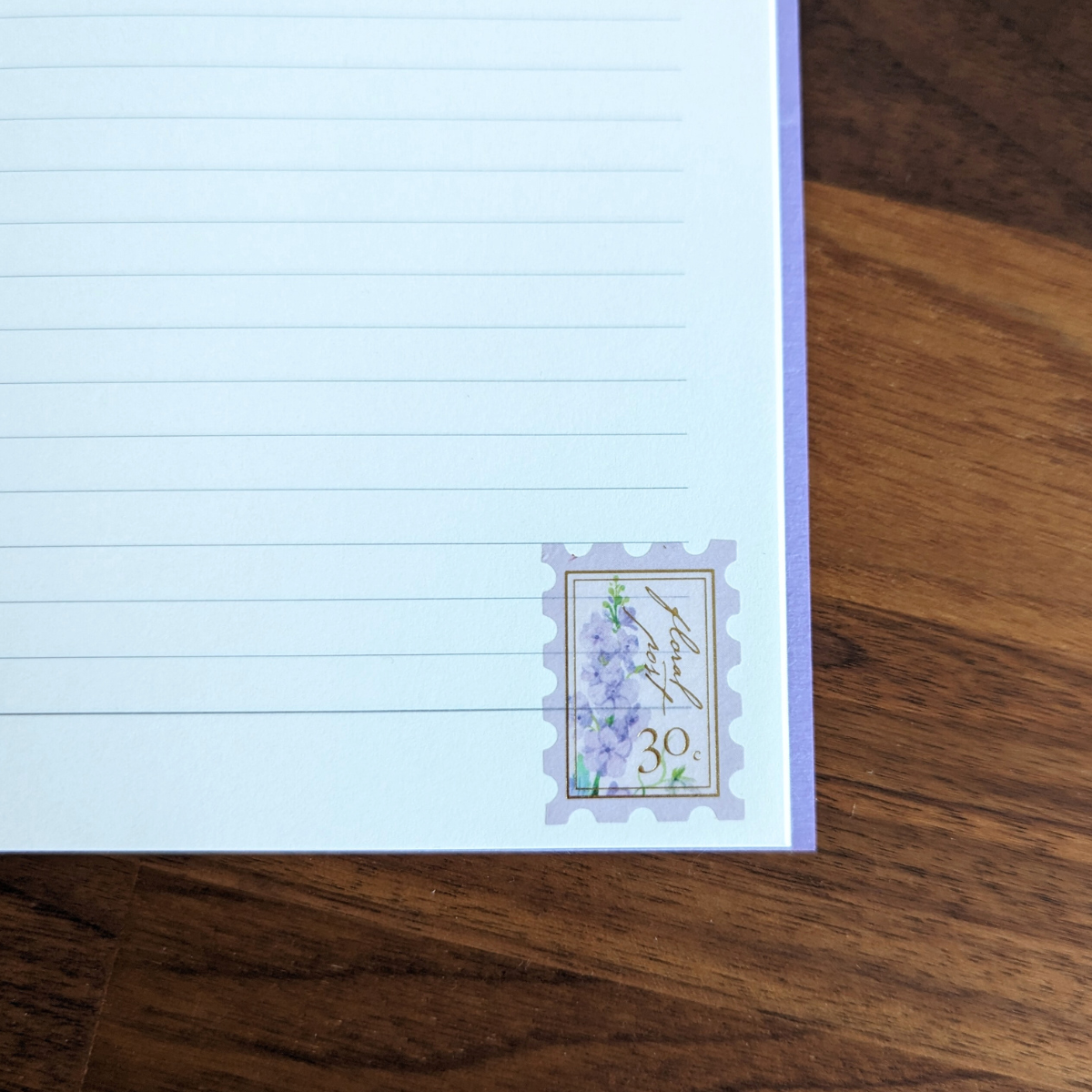 Pochette de 45 stickers en forme de timbres avec des motifs de fleurs dans les tons violet.