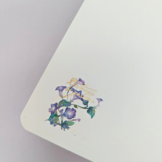 Pochette de 45 stickers en forme de timbres avec des motifs de fleurs dans les tons violet.