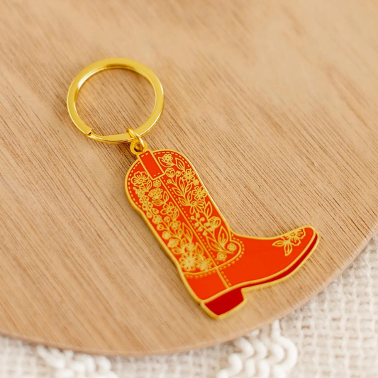 Sa forme emblématique évoque l'aventure et l'authenticité de l'Ouest américain, tandis que les détails floraux en relief ajoutent une touche de grâce et de féminité. Que vous soyez un amoureux du Far West ou que vous recherchiez simplement un porte-clés qui se démarque, cette création est faite pour vous.