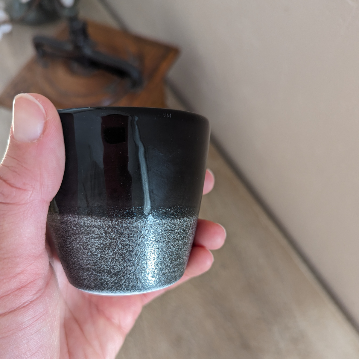 La partie inférieure de la tasse présente une texture légèrement granuleuse et un effet brillant.