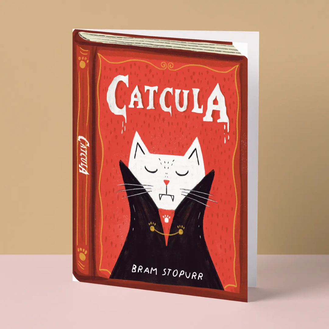 Carte illustrée par Niaski comme une couverture de livre rouge avec un chat déguisé en Dracula.
