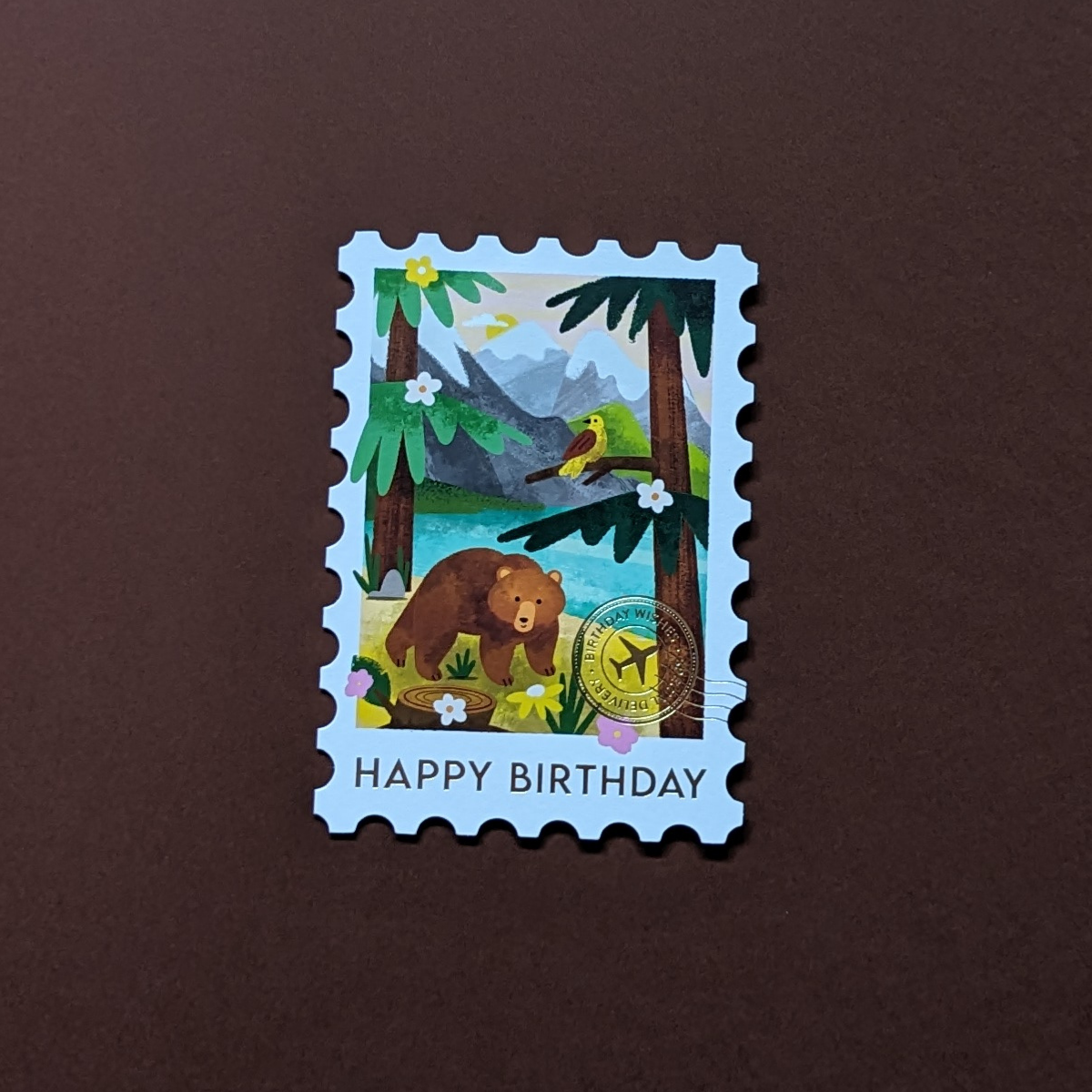 L’illustration des Rocheuses canadiennes sur cette carte découpée en forme de timbre est rehaussée d'un cachet postal doré et d'un message d’anniversaire.