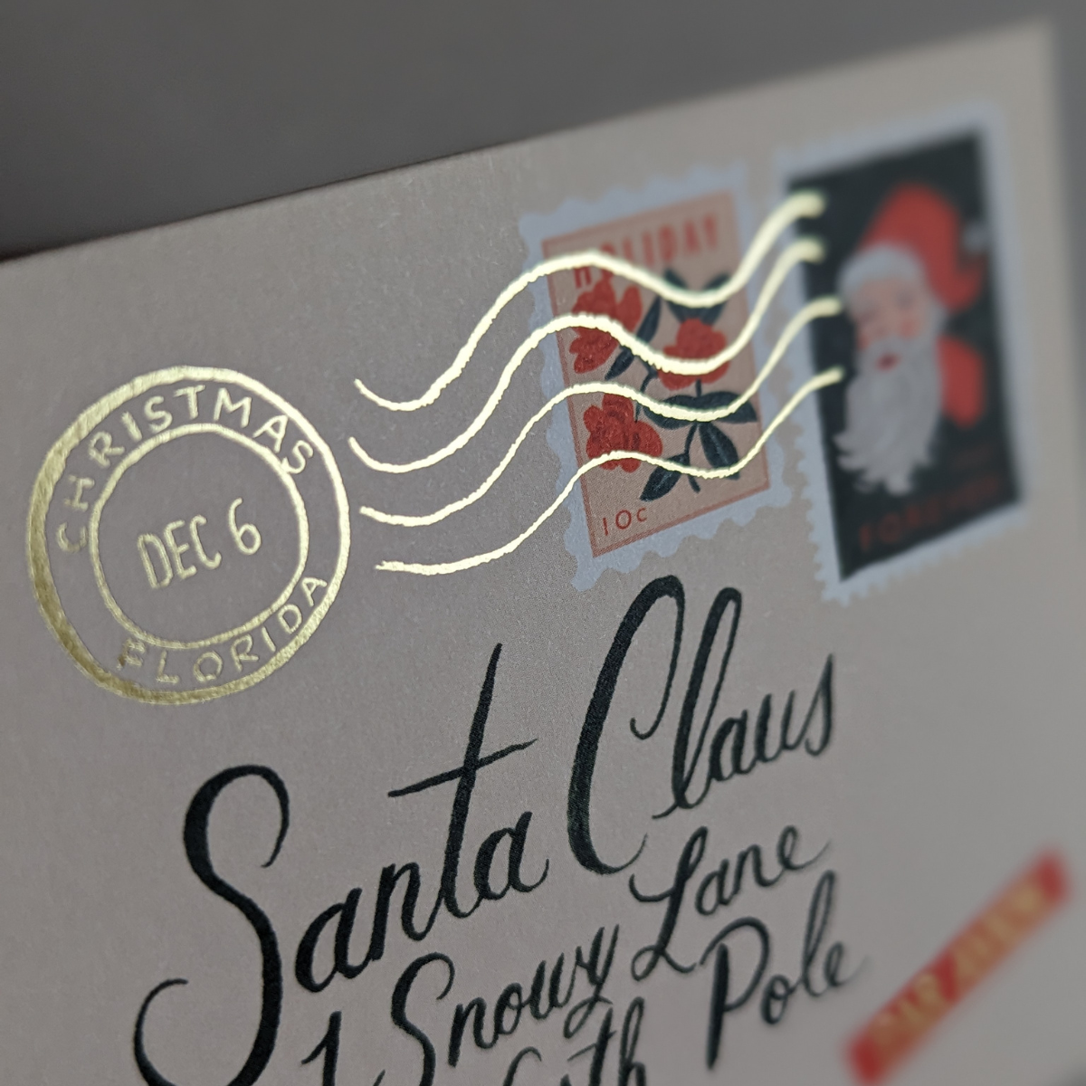 Les jolis timbres et le cachet de la poste estampé à la feuille d'or sont des détails méticuleusement conçus pour évoquer la magie de Noël.