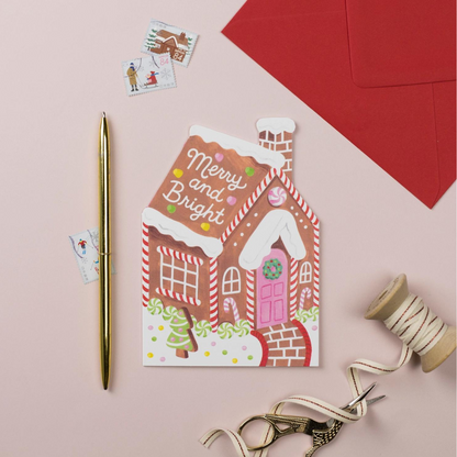 Cette charmante carte en forme de maison en pain d'épices évoque les douceurs de Noël. 