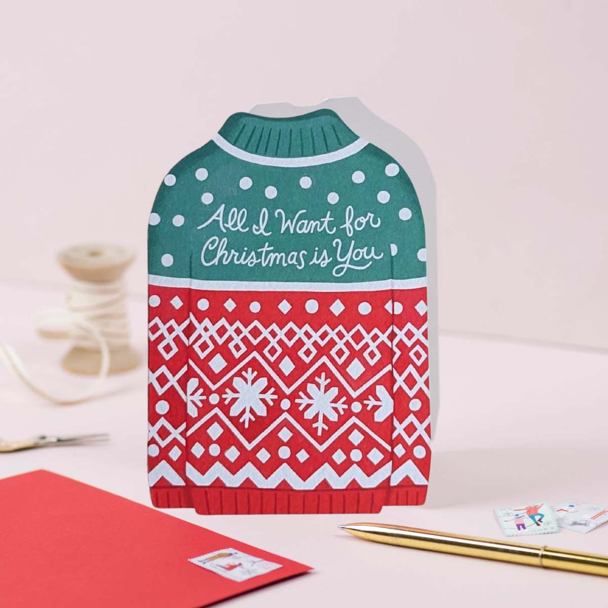 Découpée en forme de pull de Noël, cette carte évoque instantanément l'esprit festif de la saison des fêtes. Vous pouvez écrire votre message à l'intérieur.