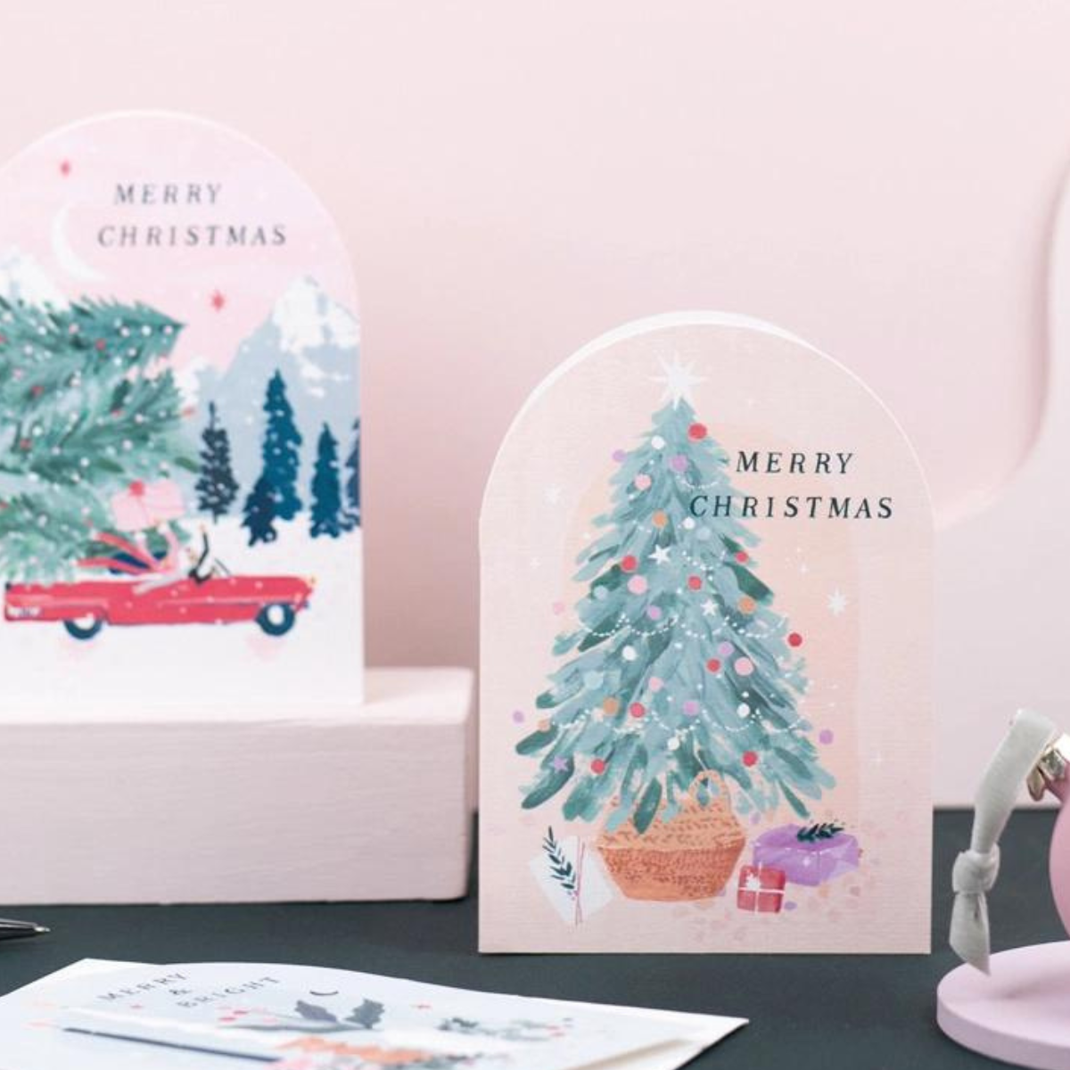 Une carte de Noël avec un sapin décoré de guirlande et de boules de Noël.