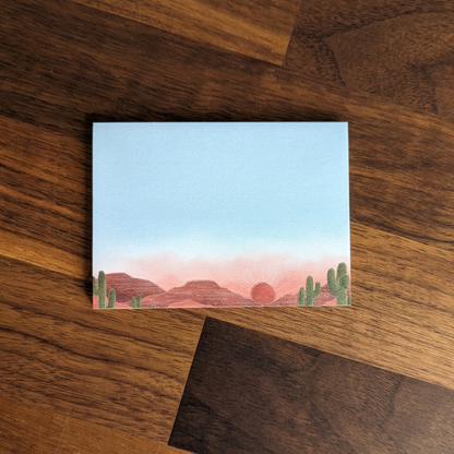 Post-it avec illustration d'un coucher de soleil sur un parc de cactus.