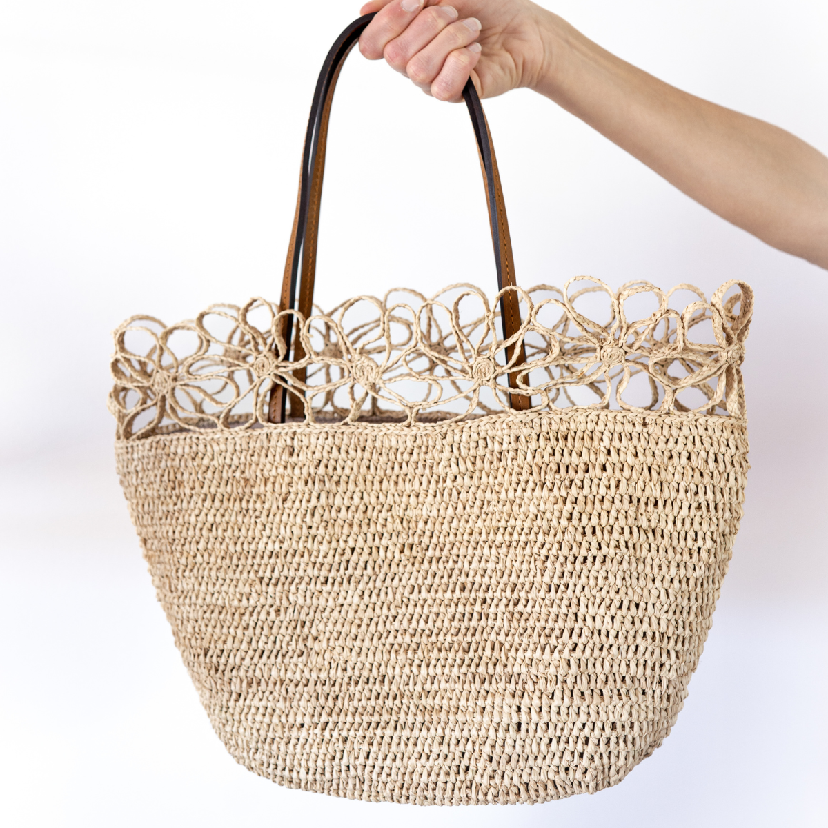 Le sac en raphia Fleur Naturel avec anses en cuir marron est l'accessoire incontournable pour toutes les amatrices de mode qui recherchent à la fois élégance et originalité.