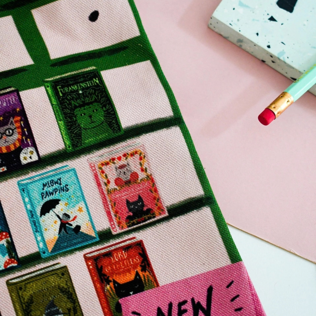 Détail du tote bag Niaski avec devanture de librairie et livres illustrés.